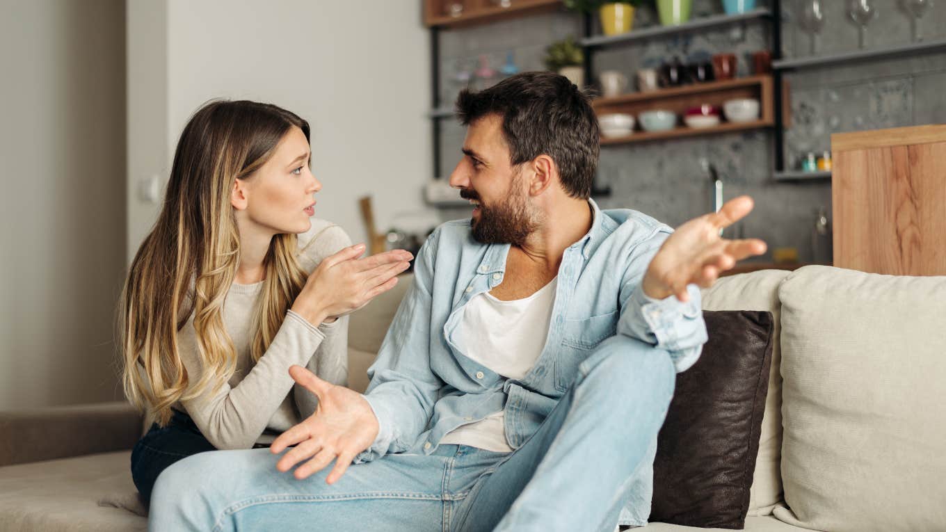 couple arguing while sitting on a couch in the living room