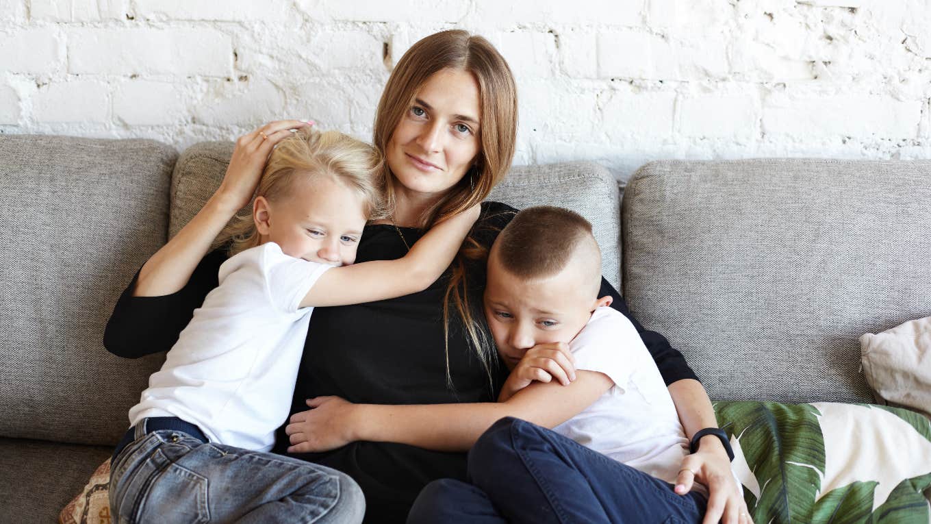 mom hugging two young boys on couch