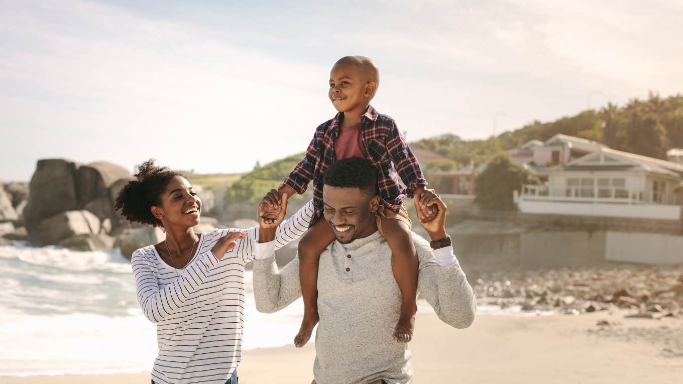 family laughing and having fun while walking on the beach