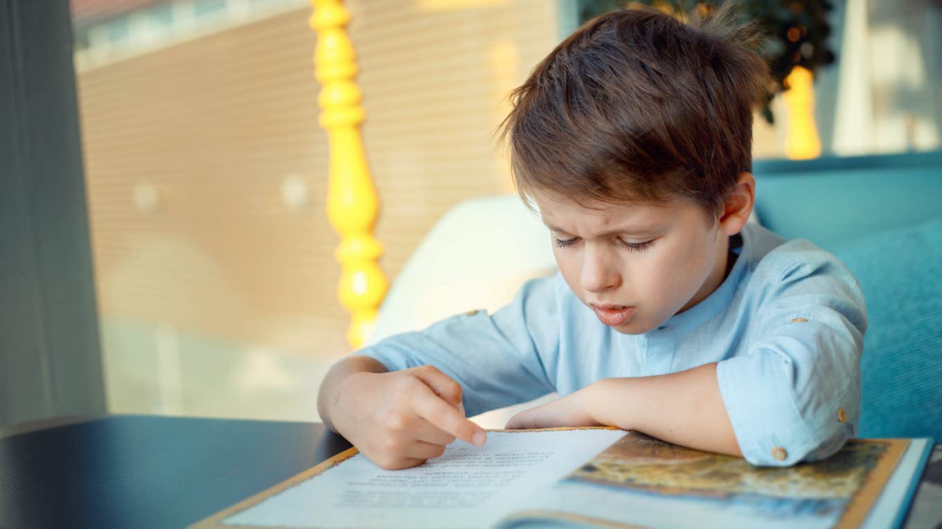 little boy struggling to read