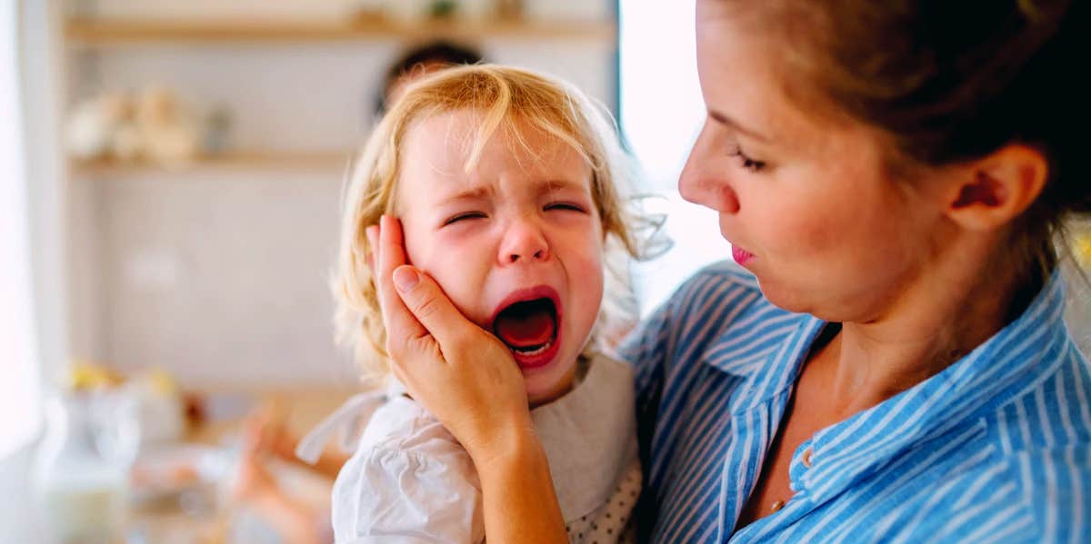 woman holding screaming child
