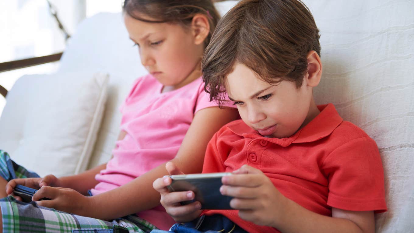 Children playing on mobile phones on sofa