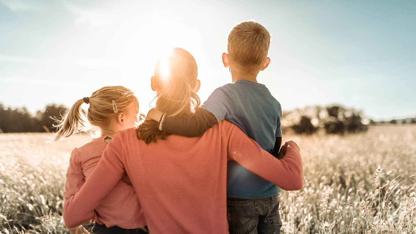 mom and two kids in field