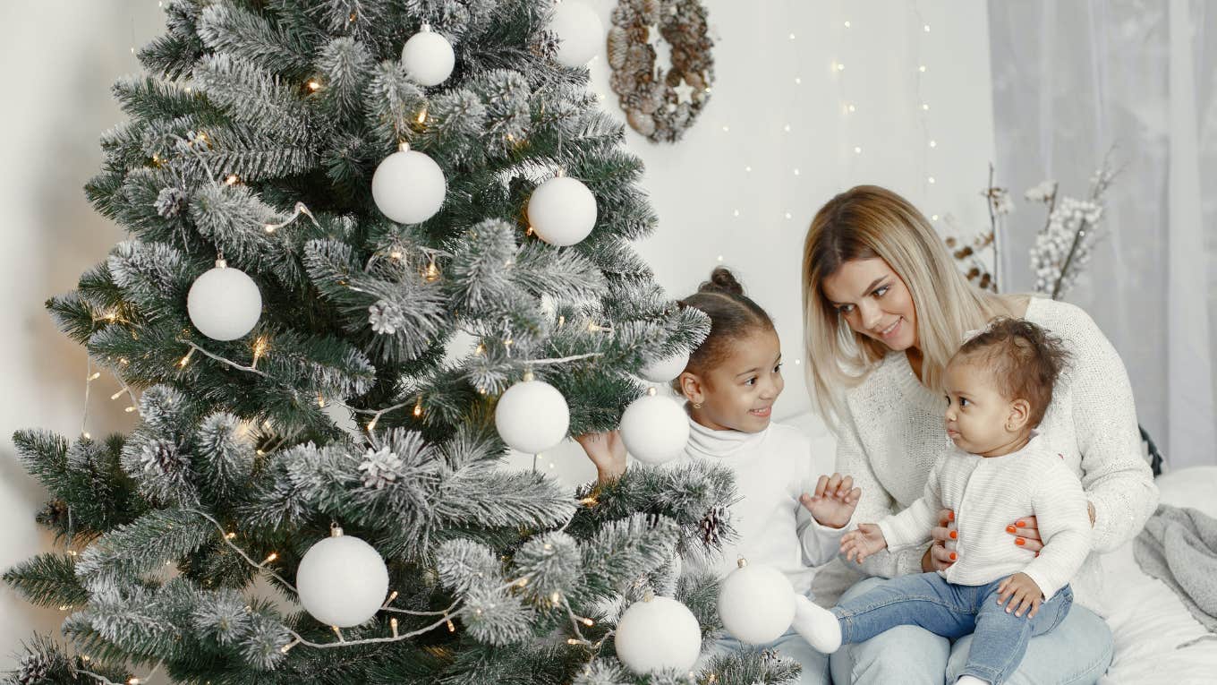 mom with two kids next to christmas tree 