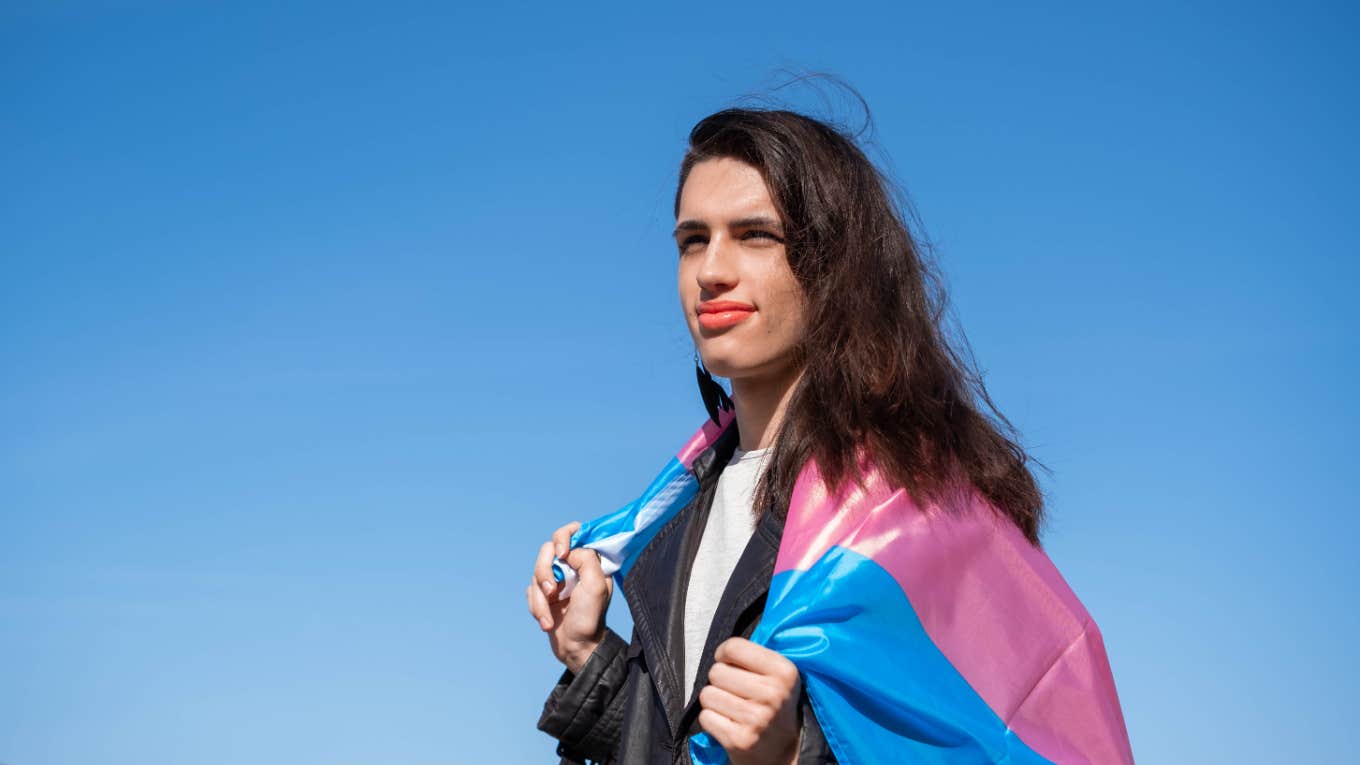 trans girl holds trans flag