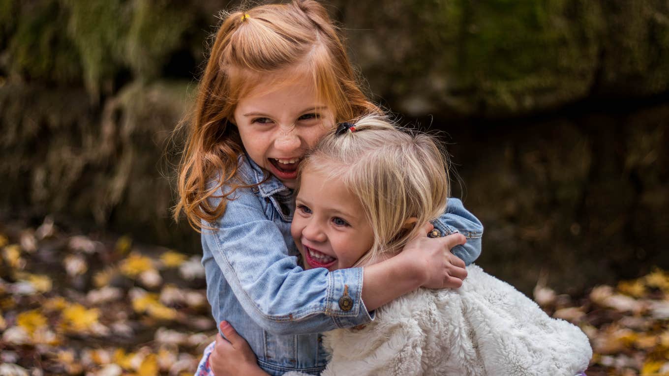 two little girls laughing and hugging each other