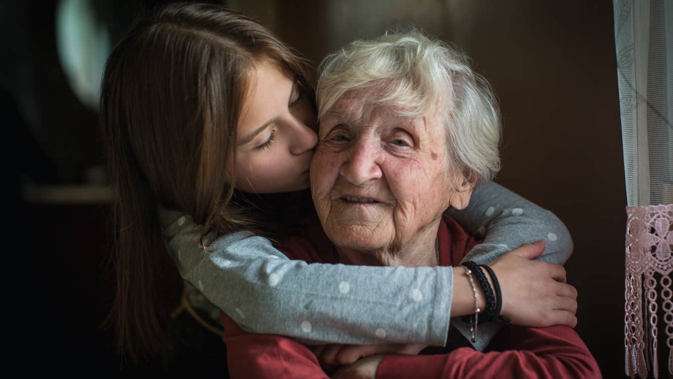 little girl hugging elderly woman