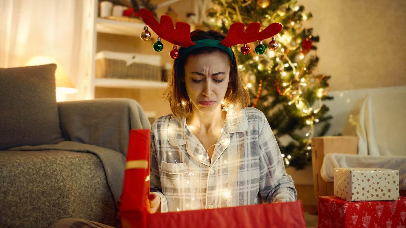 unhappy woman opening christmas gift