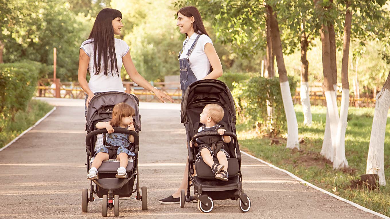 two moms walking with their kids in strollers 