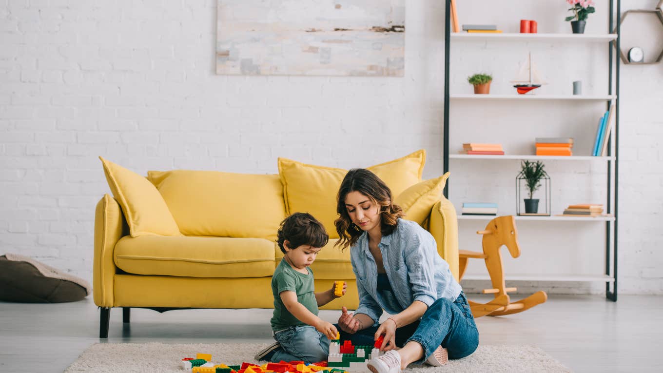 mom and son playing on floor with legos