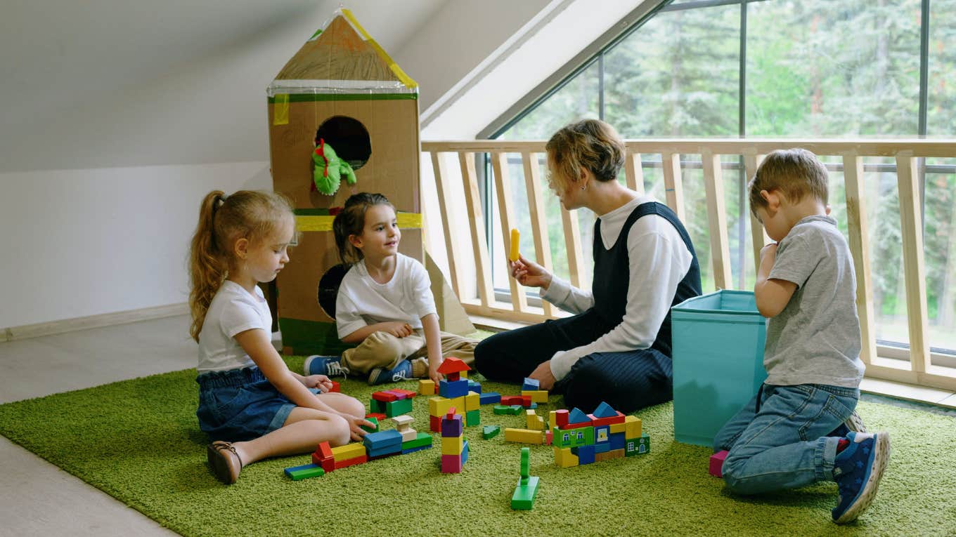 woman playing blocks with three kids