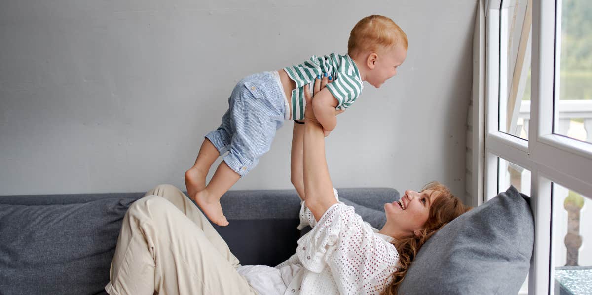 Mom holding a baby up in the air 