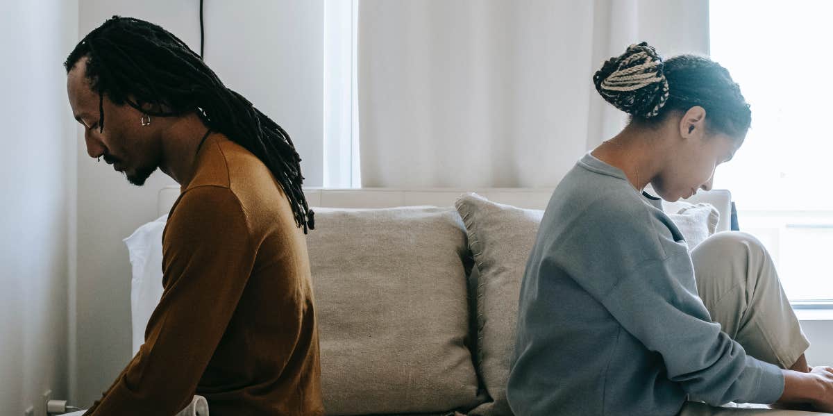 Mom Worries She's 'Selfish' For Wanting To Leave 15-Year Relationship 'Just Because She's Not Happy' man and woman sitting back to back on bed