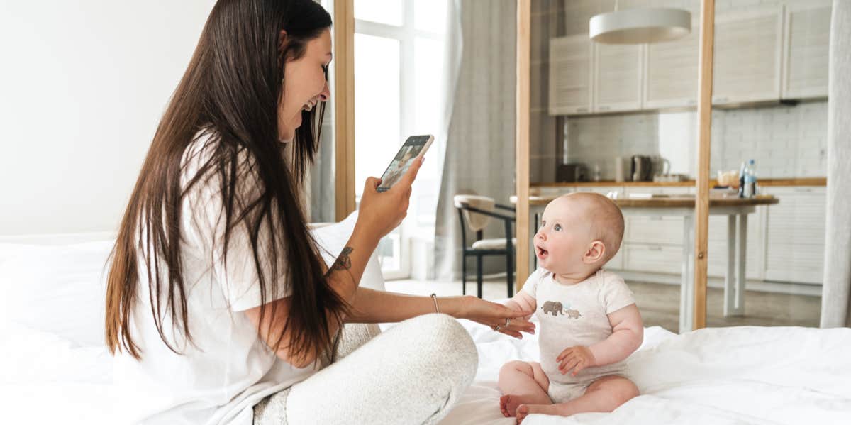 woman taking photo of baby