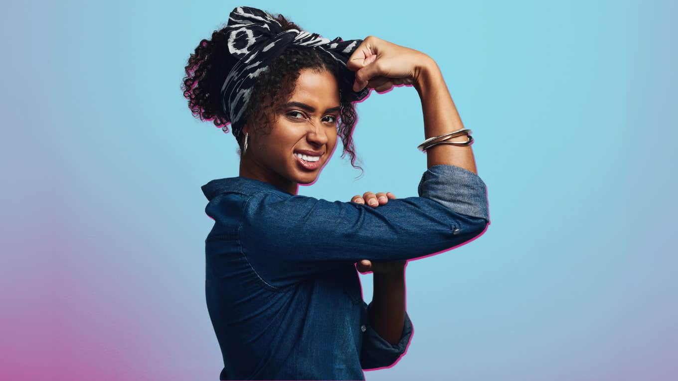 a woman poses like Rosie The Riveter