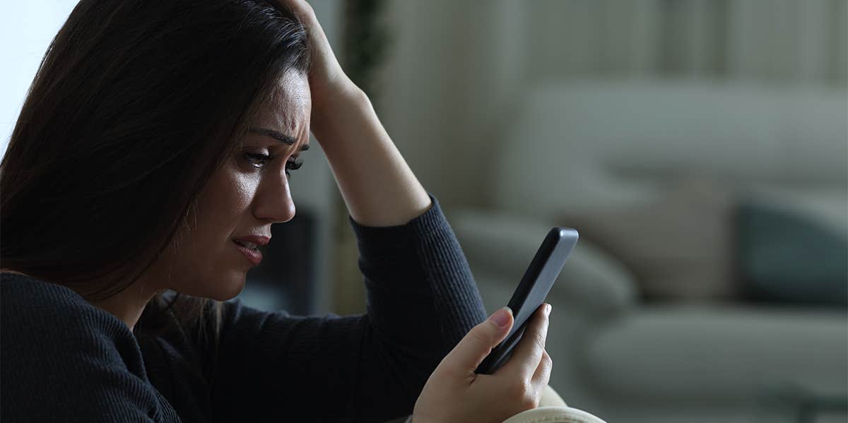 sad woman looking at phone