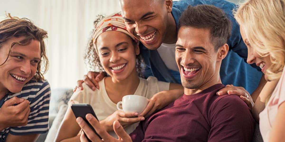 friends laughing around a phone