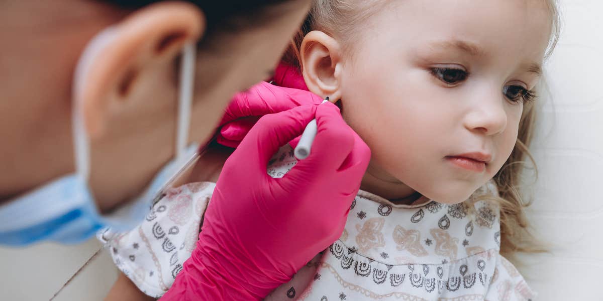 little girl getting her ears pierced