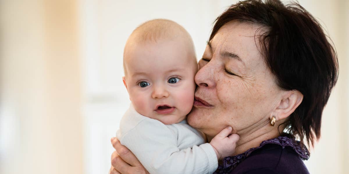 Grandmother kissing grandchild on the head