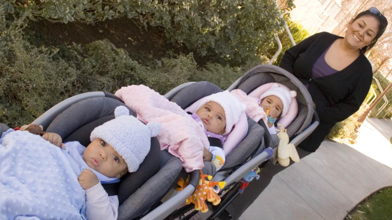 woman pushing triplet babies in a stroller