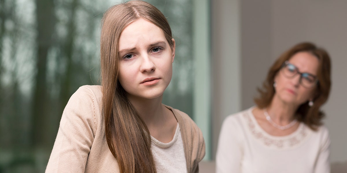 The Anti-Mother: My Mom Never Wanted To Be A Mom And It Was Obvious daughter looking strained with mom in background