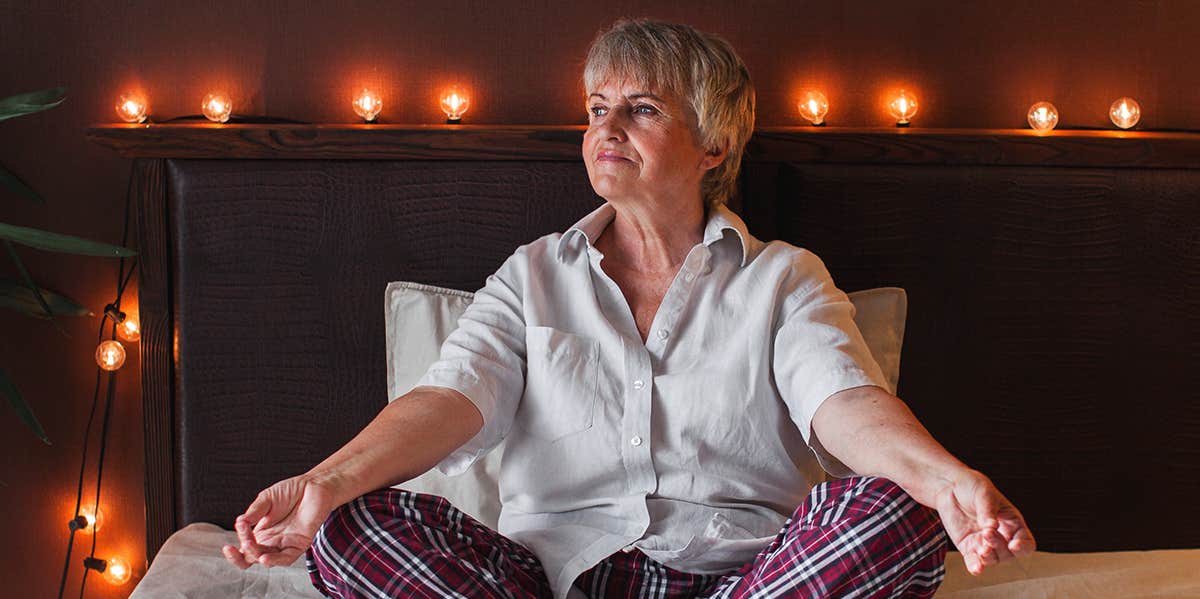 elderly woman sitting on bed