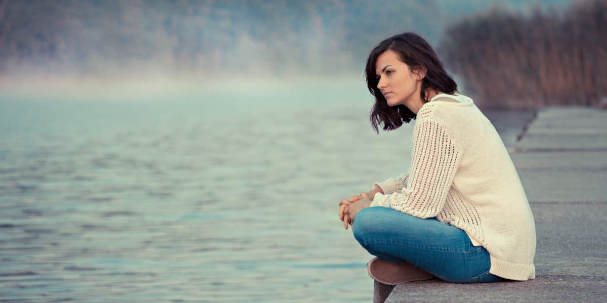 woman sitting alone looking into distance