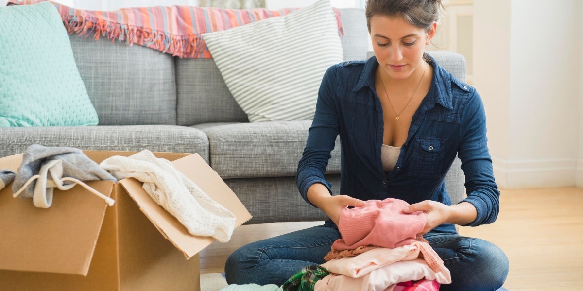 woman packing clothes in a box