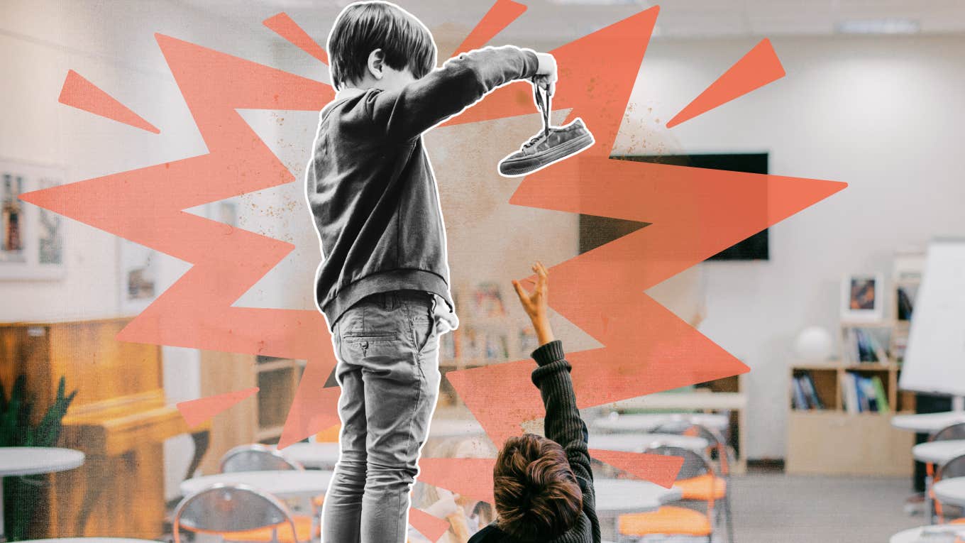 Little boy holding other Childs shoe over his head on desk