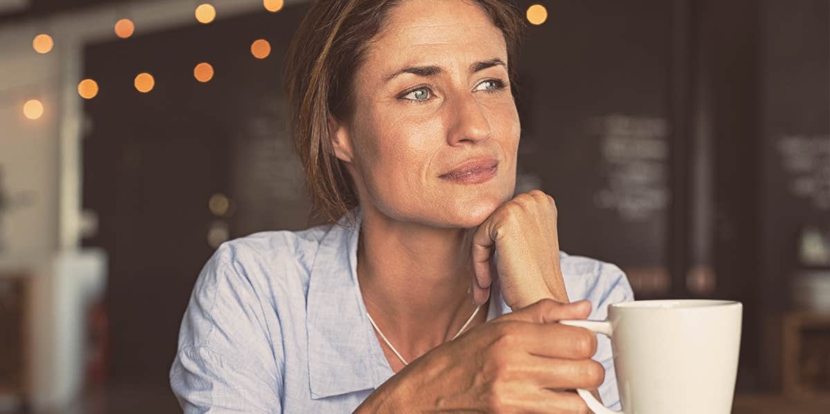 woman holding a cup, thinking