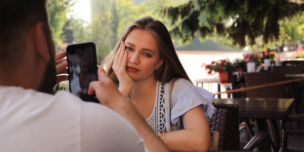 bored girl on date with guy who's on his phone