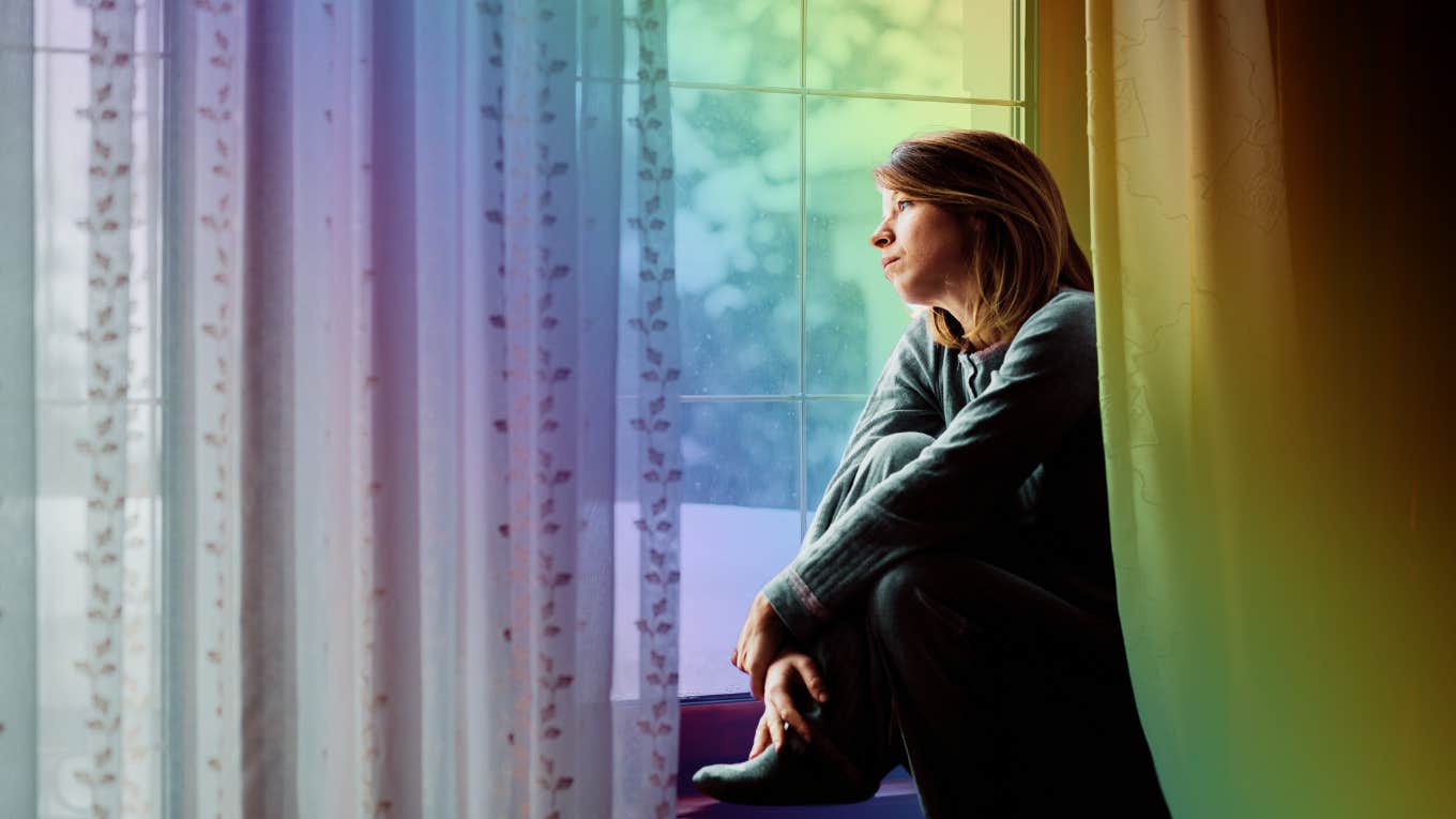 Woman looking out the window of her home