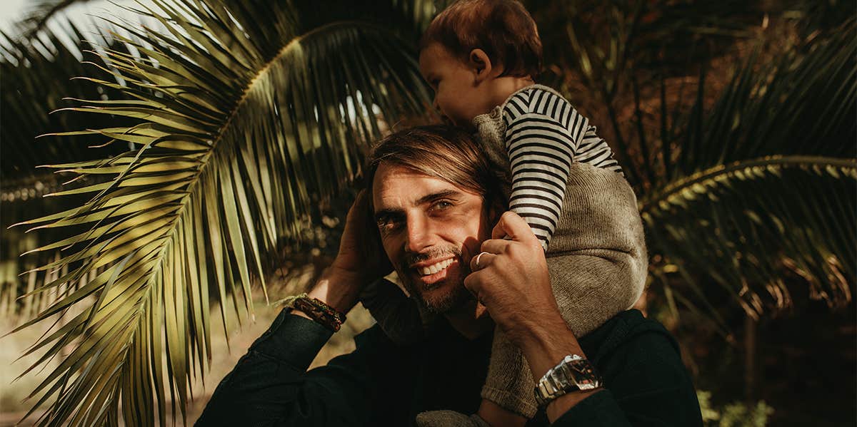 father carrying young son on shoulders