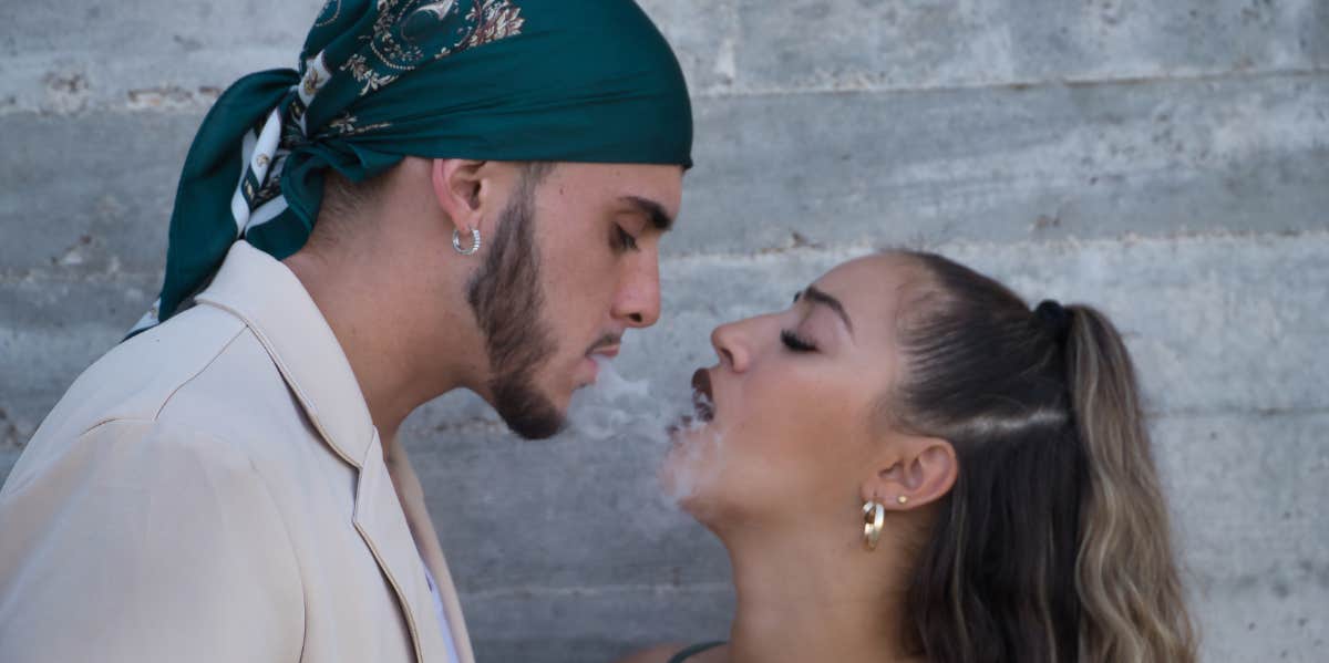 man and woman facing one another with smoke