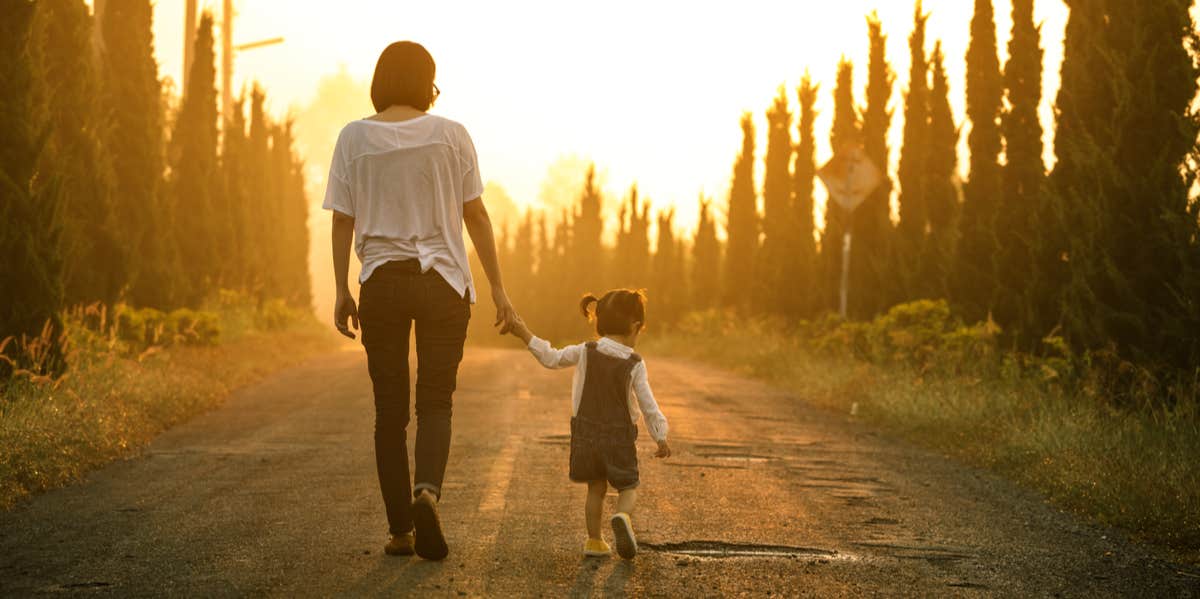 woman walking with toddler holding hand