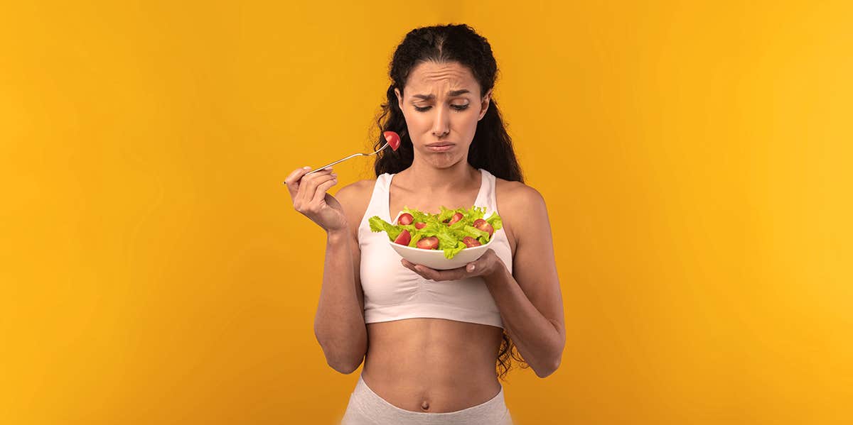 Orthorexia: My Obsession With Eating Healthy Almost Killed Me woman eating a salad, not liking it