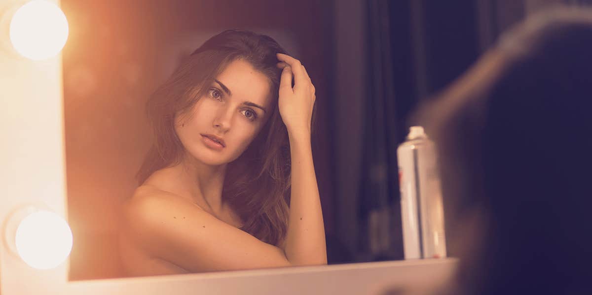 My Struggle With Anorexia Was My Body Telling Me I Was Gay woman looking into the mirror