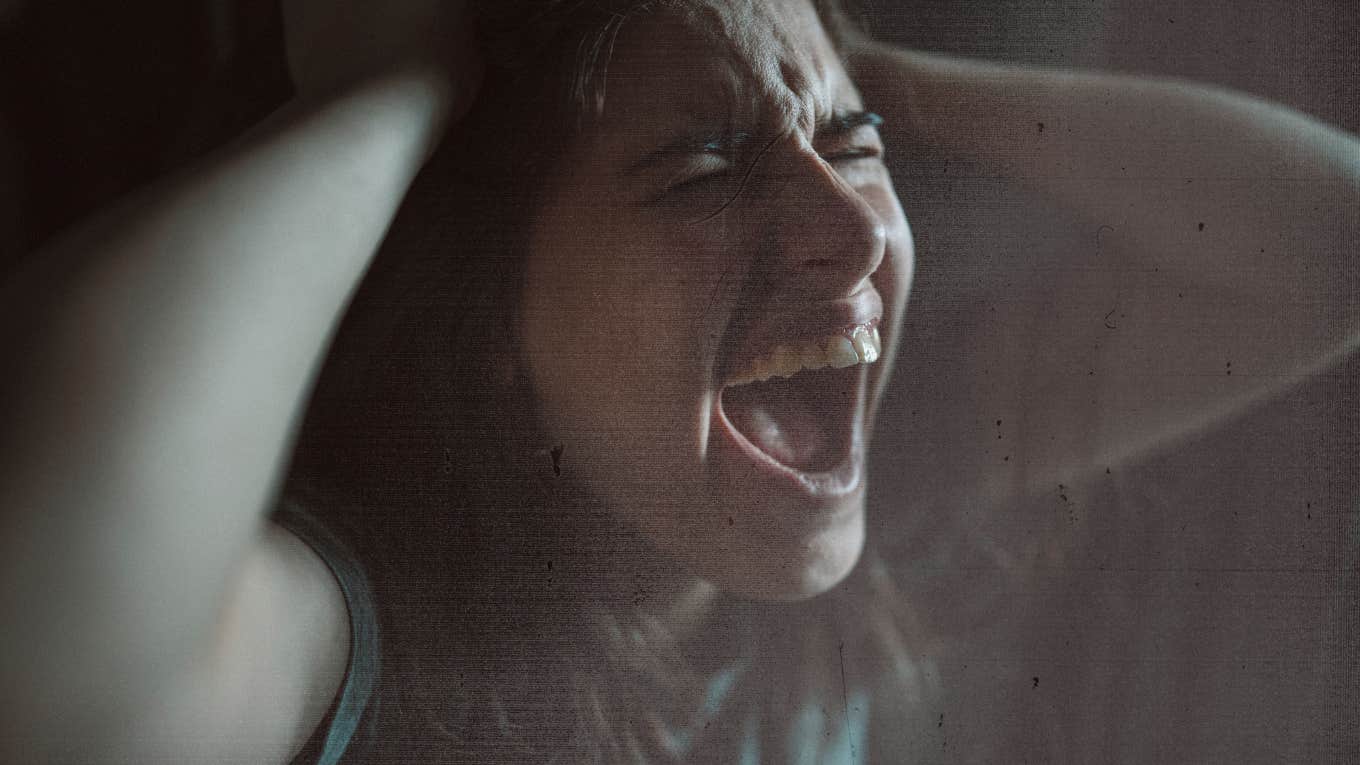Woman screaming holding her head, anger and sadness