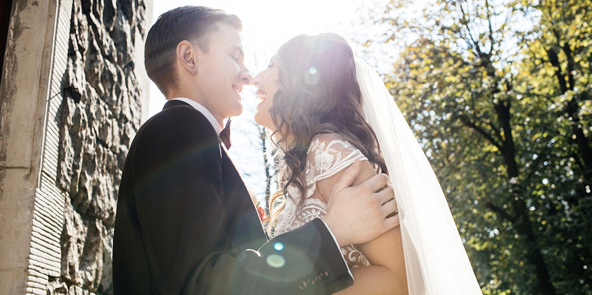 bride and groom kissing in sunlight