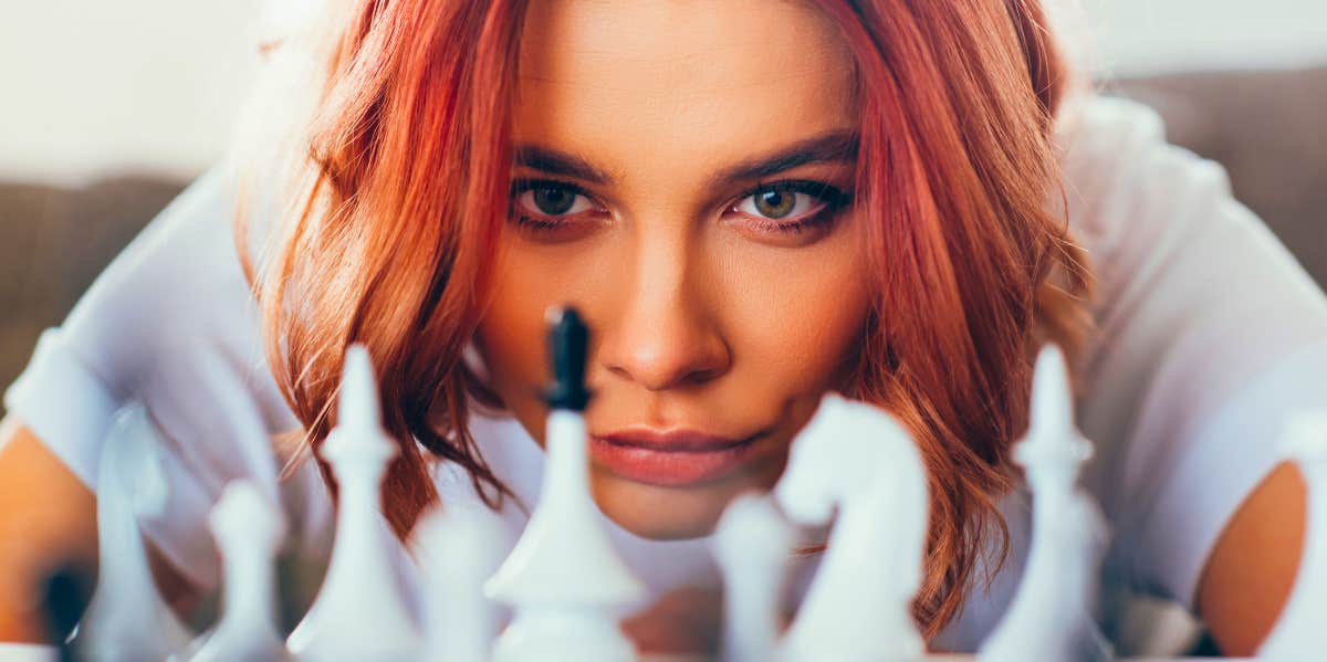 young woman concentrating on a chess game