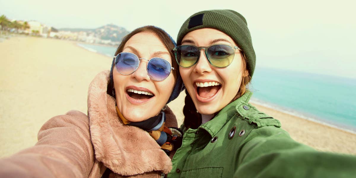 Mother and daughter in sunglasses on the beach