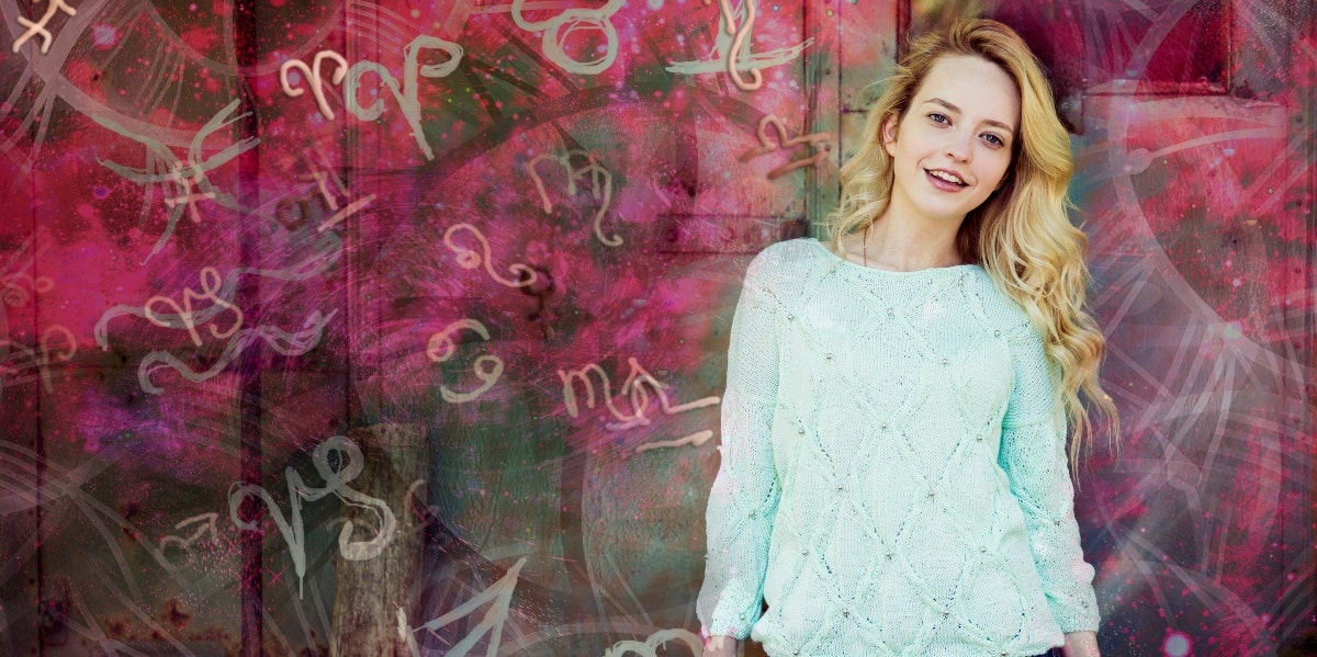 woman standing by wall with astrology signs