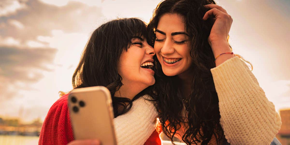two girl friends taking selfie and laughing