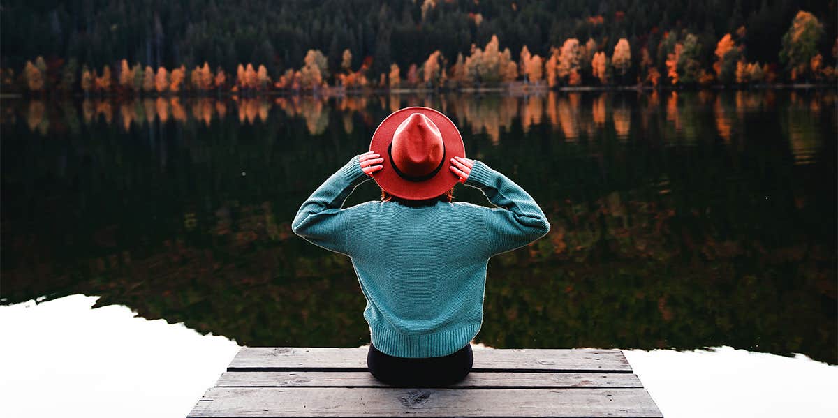 woman sitting on dock by river