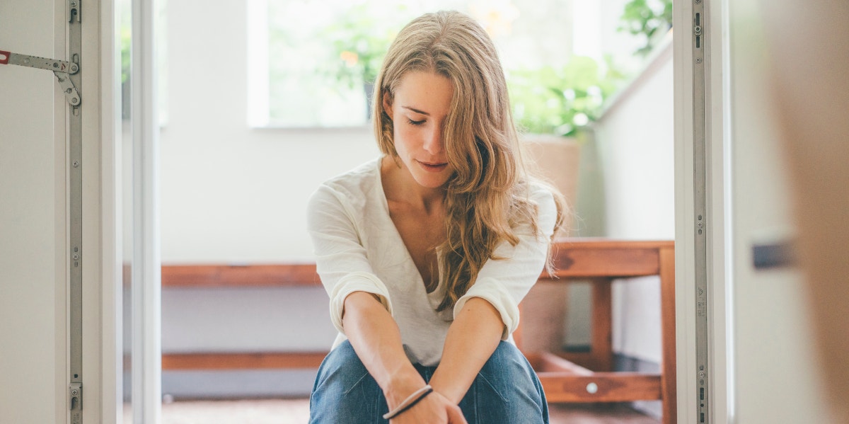 woman sitting on stairs with hands on her knees