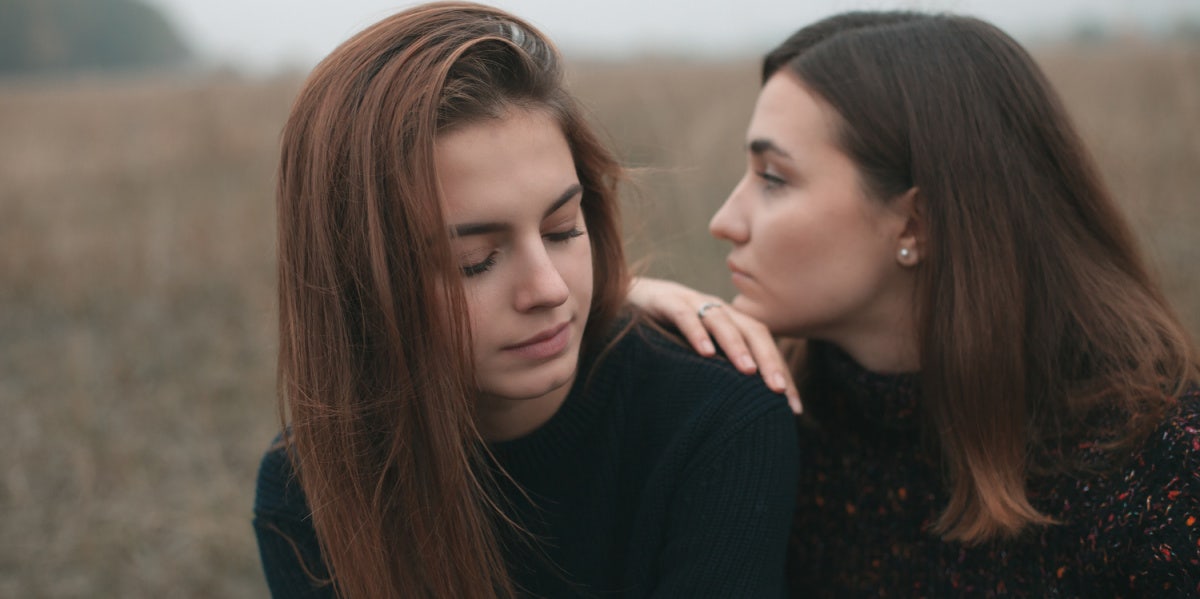 two friends leaning on each other