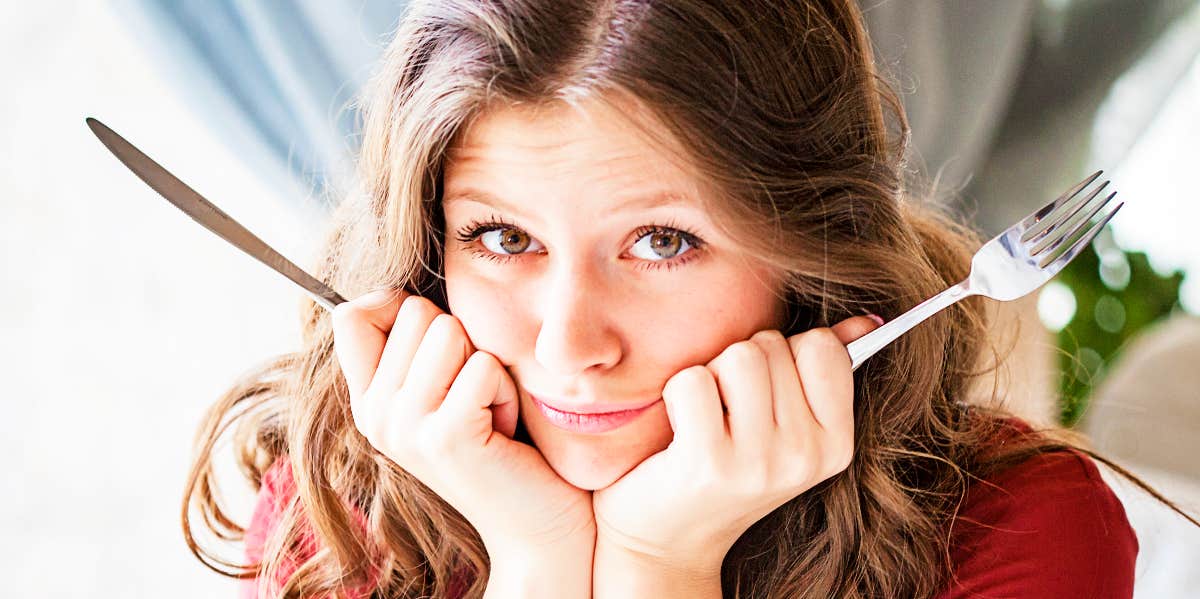 Never be hangry again Disgruntled hungry woman with knife and fork.