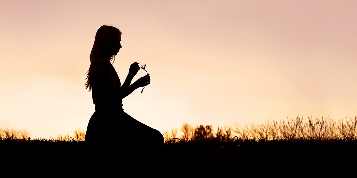 woman meditating in sunset