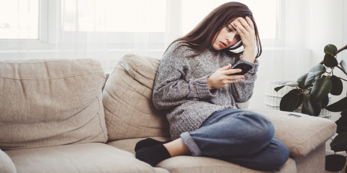 woman mad on phone on couch