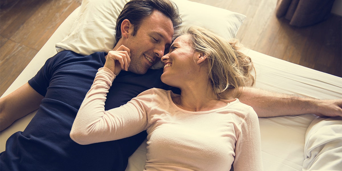 husband and wife embracing on bed